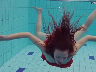 Raudonas apsirengęs paauglys plaukimas su jos akys opened